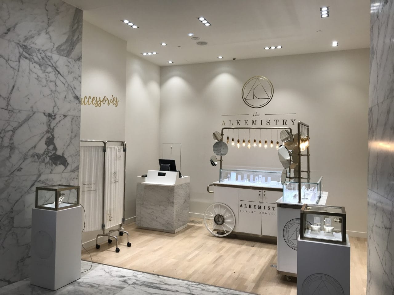 The Alkemistry store with various glass displays and marble patterned walls from the right angle.