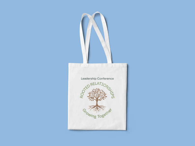 A white tote bag featuring a tree graphic is set against a light blue background. The text Leadership Conference appears above the tree, with Rooted Relationships, Growing Together below it.