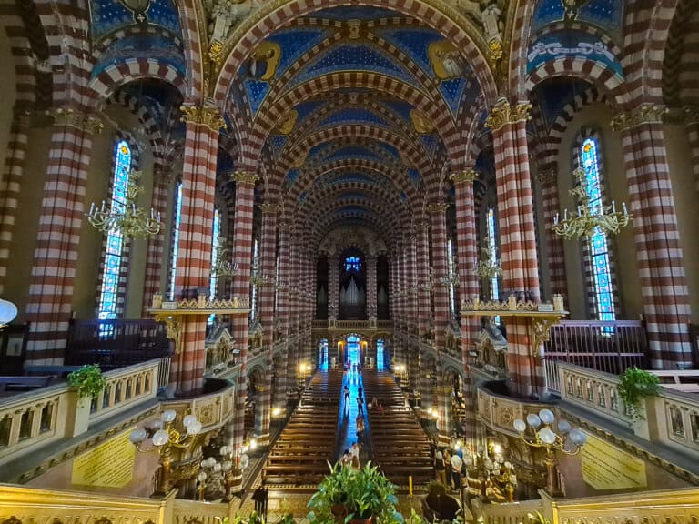 Interior of Basilica María Auxiliadora & San Carlos in Buenos Aires, a hidden architectural gem featuring vibrant neo-Gothic design, intricate stained-glass windows, and ornate detailing. Located off the beaten track, this stunning basilica offers visitors a serene and awe-inspiring experience, showcasing the city's rich religious and cultural heritage.