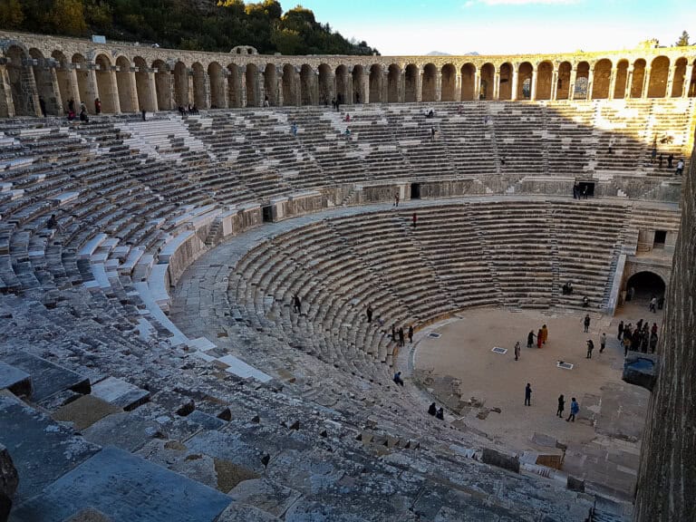 The semi-circular amphitheatrical seating area and the vaulted arcade at the top of the Roman Theater of Aspendos in Turkiye
