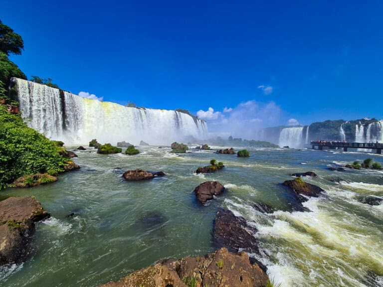 A picture of Iguazú Falls showing expansive waterfalls cascading down in a powerful display of nature's force.