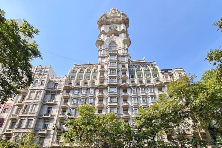 The magnificent exterior of Palacio Barolo in Buenos Aires, showcasing its iconic architecture inspired by Dante's Divine Comedy. This historic skyscraper features ornate details, lush greenery, and a unique design that stands out on Avenida de Mayo. A must-see landmark in Argentina.