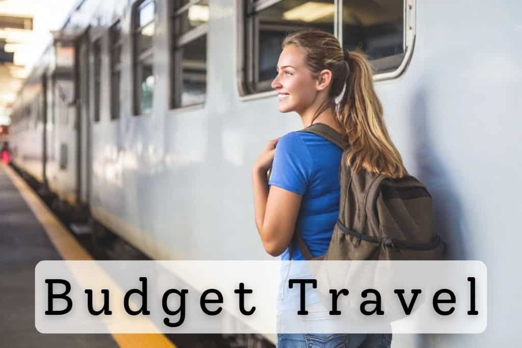 Smiling female traveler with a backpack standing on a train platform, ready to board an affordable train, symbolizing budget-friendly travel options and exploration.