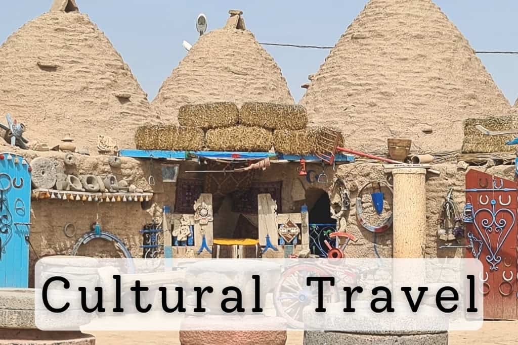 Traditional clay domed houses adorned with colorful decorations, antique tools, and vibrant doors, showcasing cultural heritage and unique architectural styles.