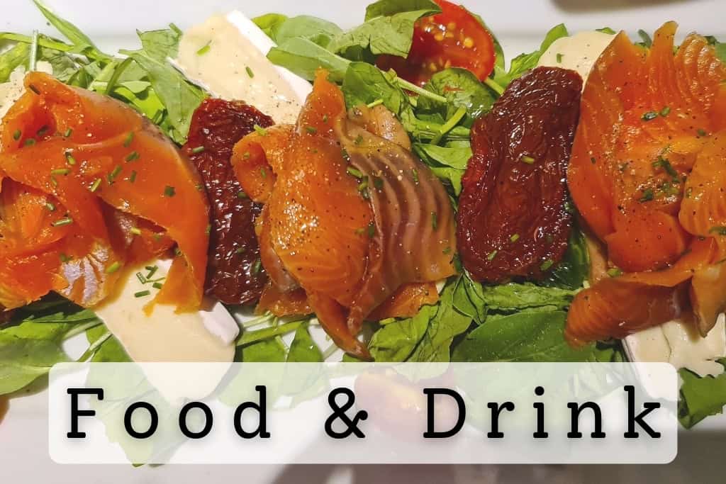 Delicious smoked salmon salad with fresh greens, sun-dried tomatoes, and cheese slices, highlighting gourmet dining and culinary experiences around the world.