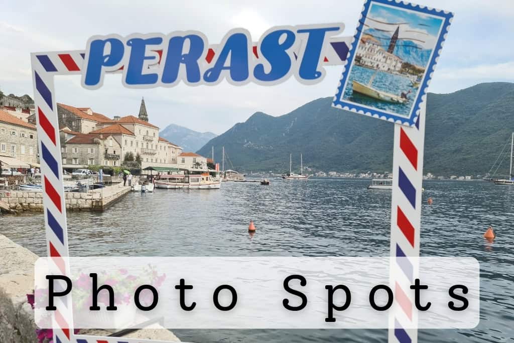Framed photo spot in Perast overlooking the picturesque waterfront, traditional stone buildings, and serene bay surrounded by lush green mountains, perfect for travel photography.