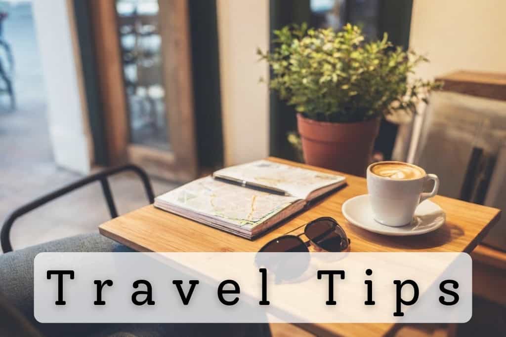 Cozy cafe table with a map, notebook, sunglasses, and a cup of coffee, symbolizing travel planning and practical tips for an organized trip.