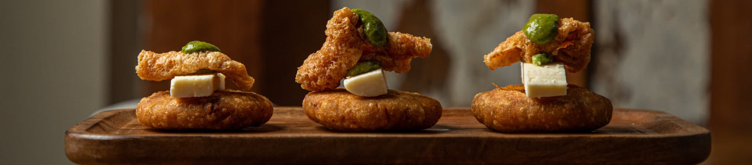 Chicharrón Arepitas at Origen Bistro: Crispy mini corn arepas with pork cracklings, a Venezuelan specialty in New Orleans. Origen bistro contact us