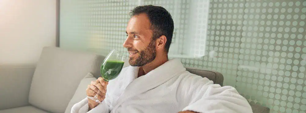 A rich and powerful man drinking a nutrient-rich smoothie for breakfast in his dressing gown