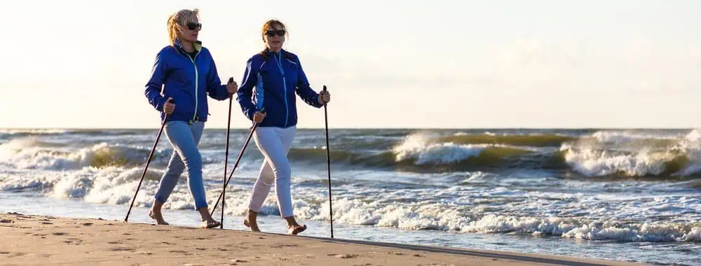 Two women walking at speed on a beach