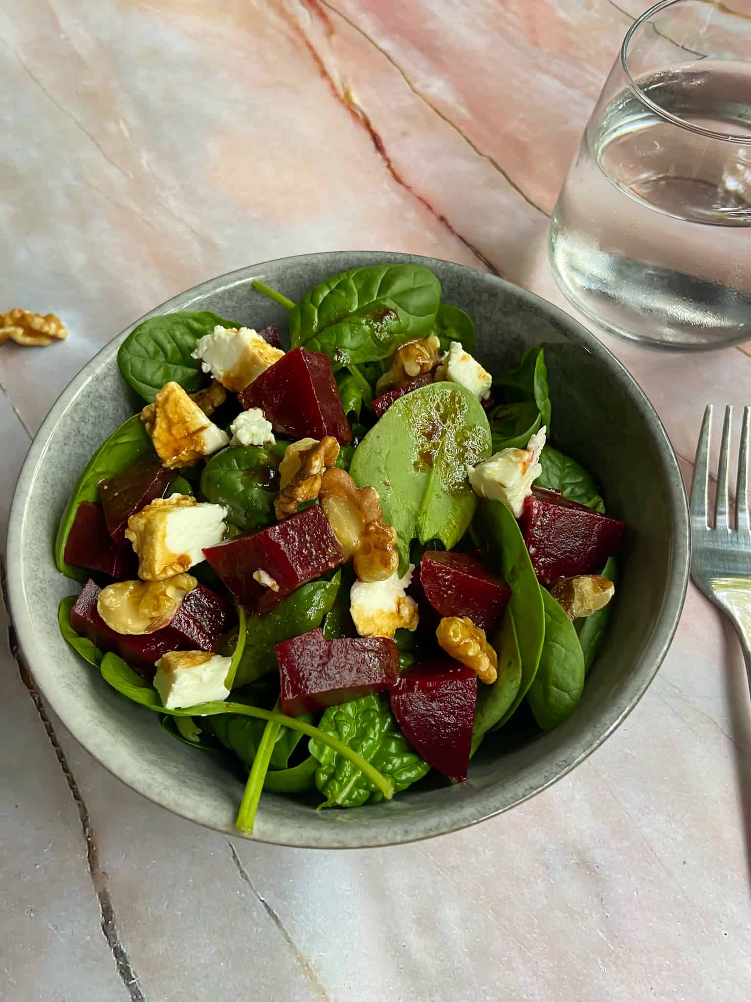 beetroot goat cheese salad with fork and water on the table