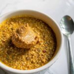 Pumpkin overnight oats in a ramekin with peanut butter.