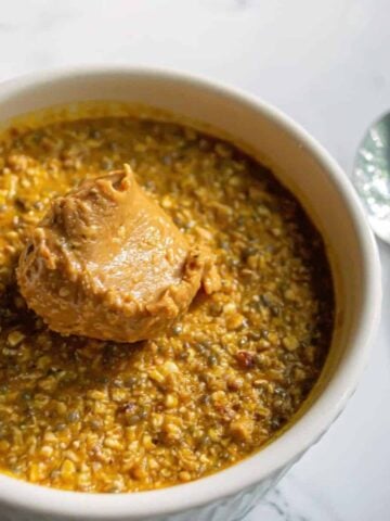 Pumpkin overnight oats in a ramekin with peanut butter.