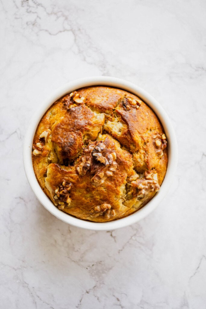 Overhead shot of a single serving banana bread made with egg on a marble table.