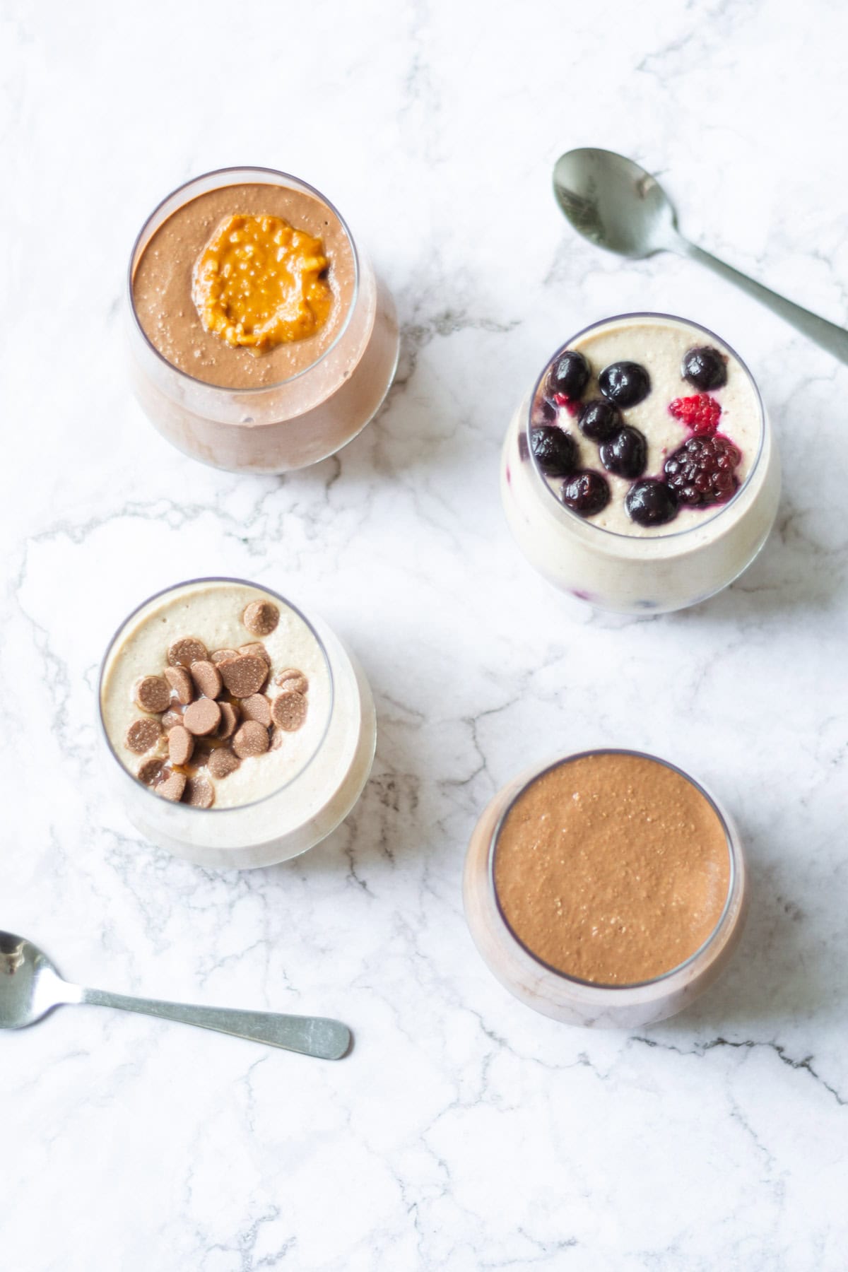 Overhead view of four flavours of blended overnight oats.