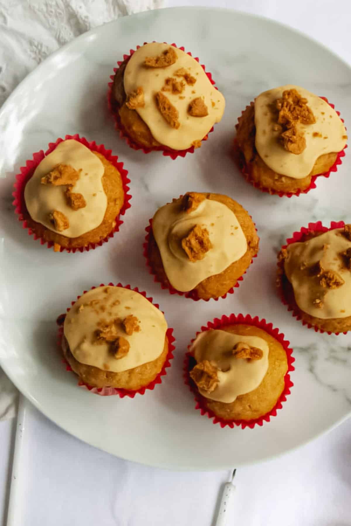 Overhead shot of vegan Biscoff cupcakes on a marble plate.