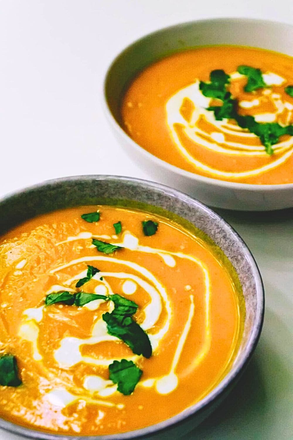 Angled view of Pumpkin soup with coriander on top.