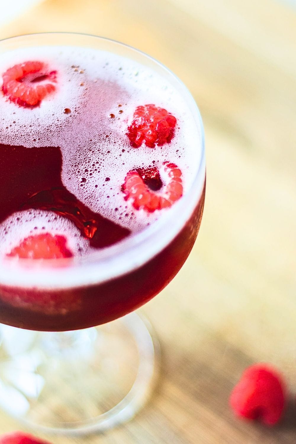 Overhead shot of Kir Royale, highlighting bubbles and raspberries.