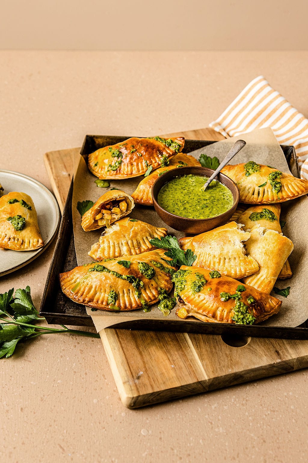 Front view of vegetarian empanadas, sprinkled with chimichurri sauce.