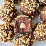 Overhead shot of Ferrero Rocher protein balls on a plate, including one with a bite taken out of it.