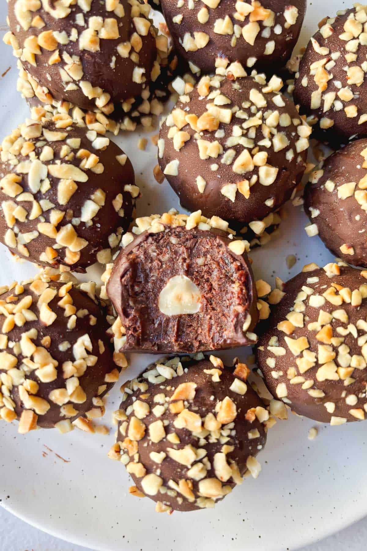 Overhead shot of Ferrero Rocher protein balls on a plate, including one with a bite taken out of it.