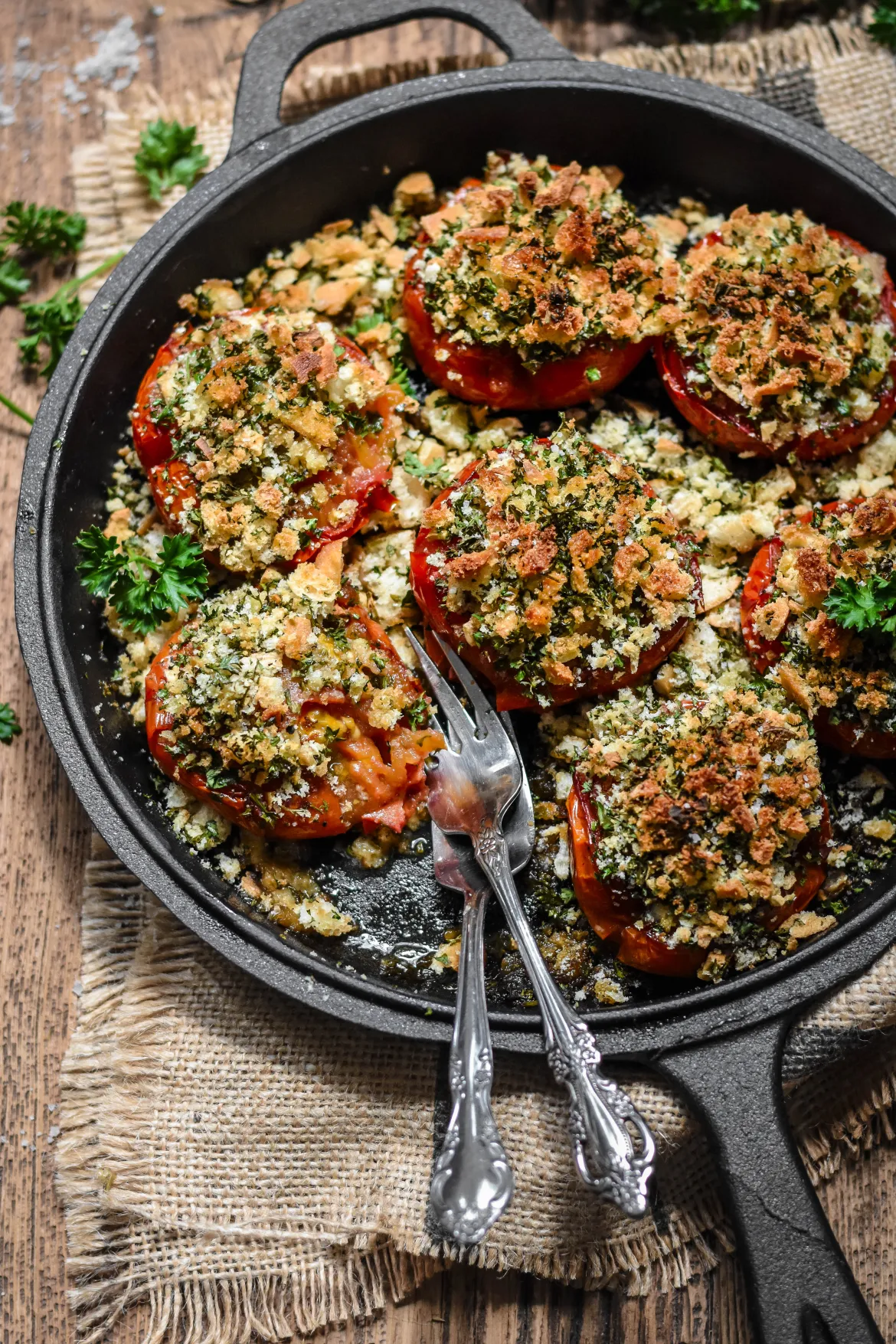 Overhead shot of provence-style baked tomatoes in a cast-iron pan.
