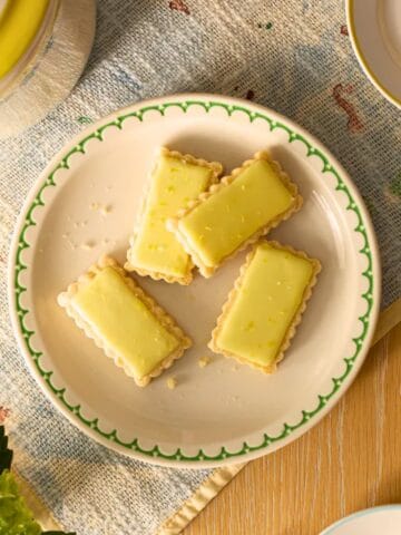 Overhead shot showing yuzu cookies with yellow glaze on a plate.
