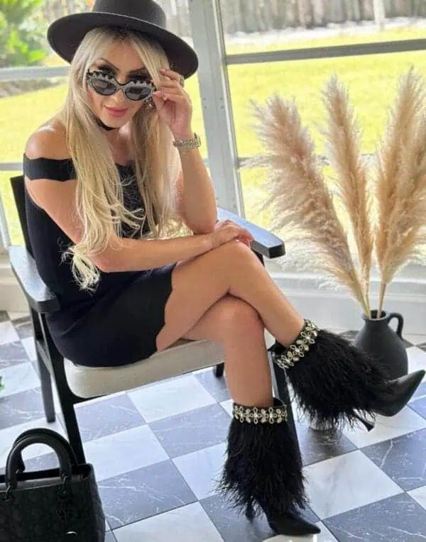 girl sitting by window with sunglasses wearing The Foxy Black Leather Stiletto Boot with Premium Feathers