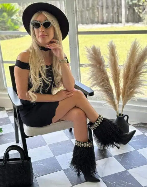 girl sitting with sunglasses wearing the The Foxy Black Leather Stiletto Boot with Premium Feathers