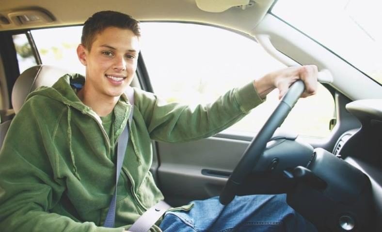 image of teen guy in driver's seat in car