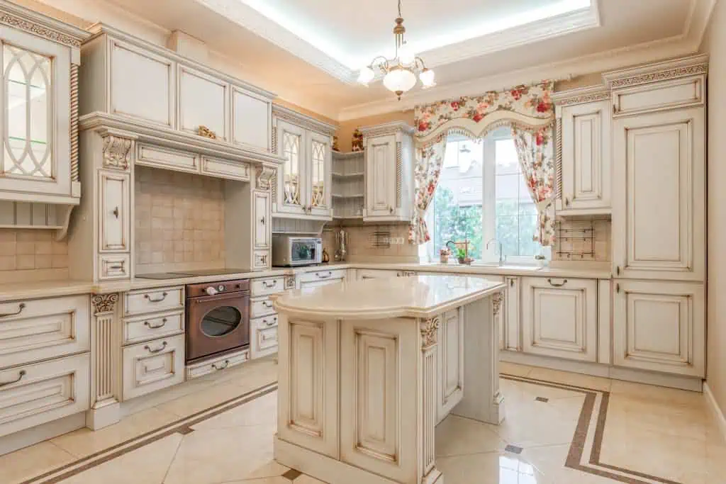 Luxury traditional kitchen featuring ornate cabinetry and a marble island.