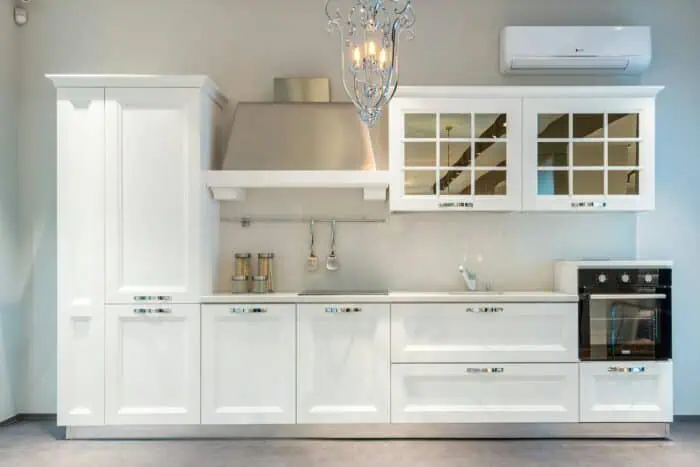 Sleek modern kitchen design featuring white cabinets and an elegant chandelier.