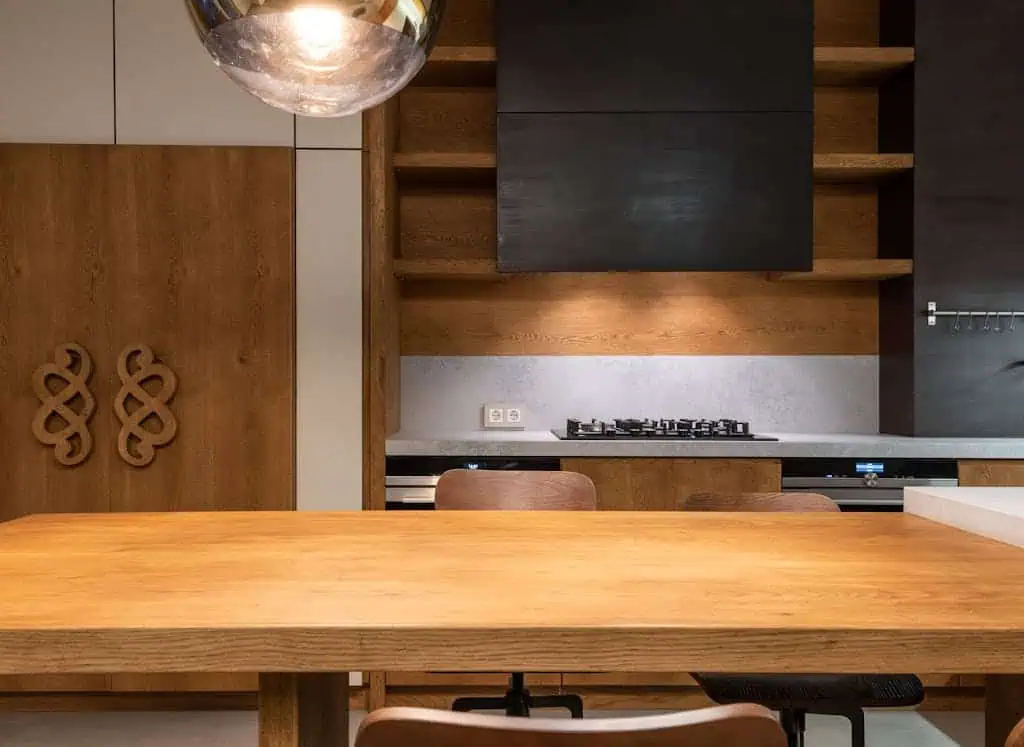 Stylish kitchen with wooden furniture, gas stove, and minimalistic decor.