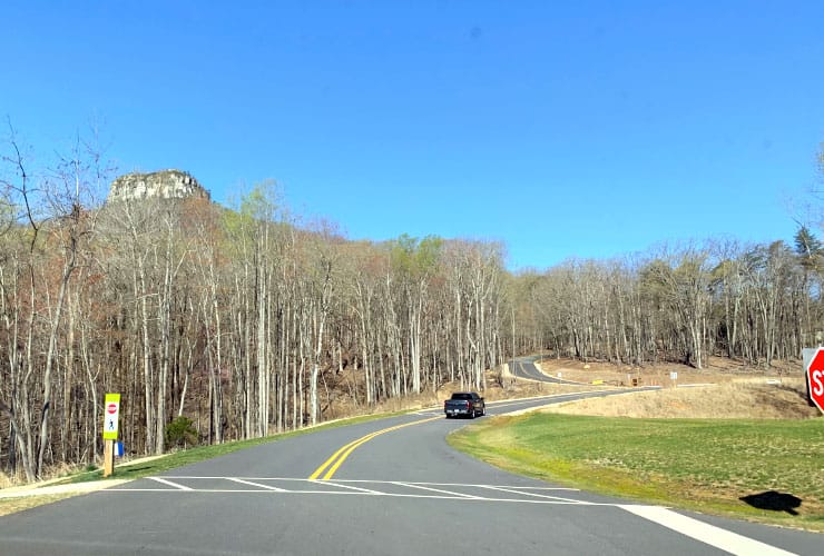 Curving ascent of Pilot Knob Park Road leading to the summit parking area.