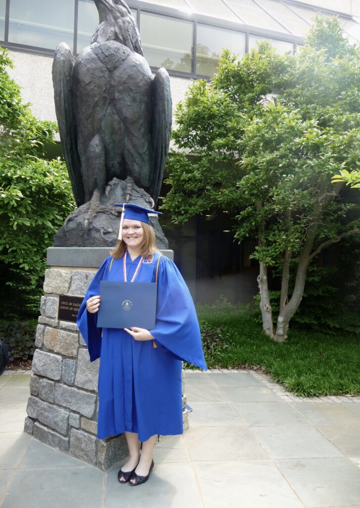 Photo of Grace with her diploma on graduation day from American University