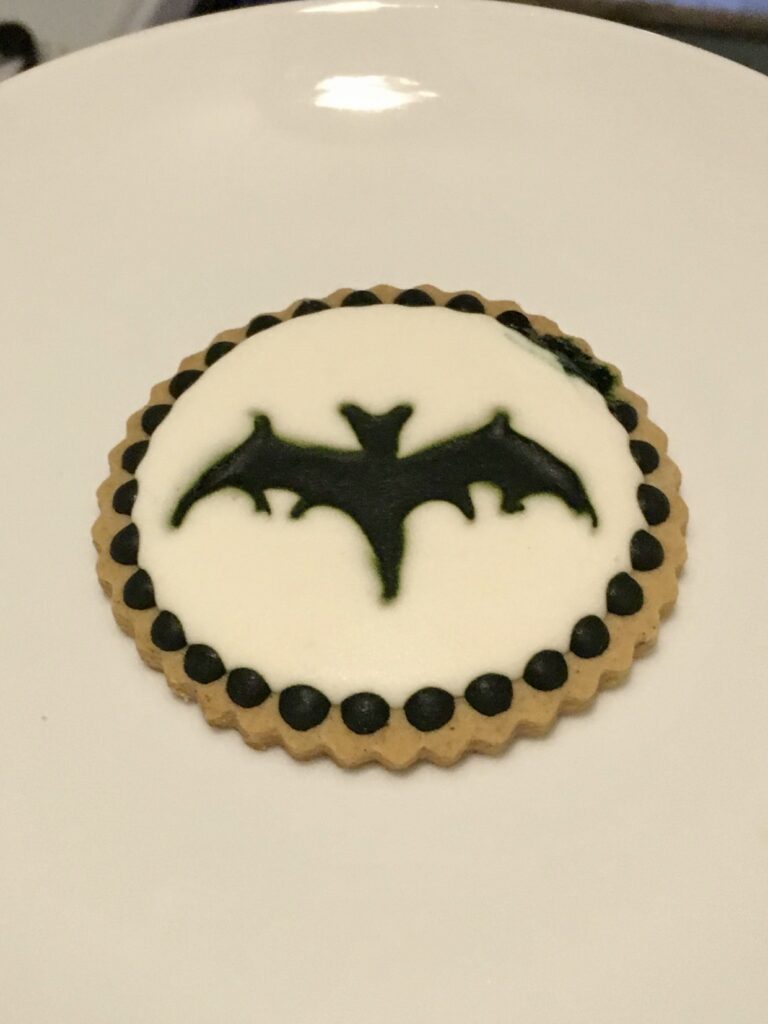 photo of a cookie with a black bat on a white background with color bleed 