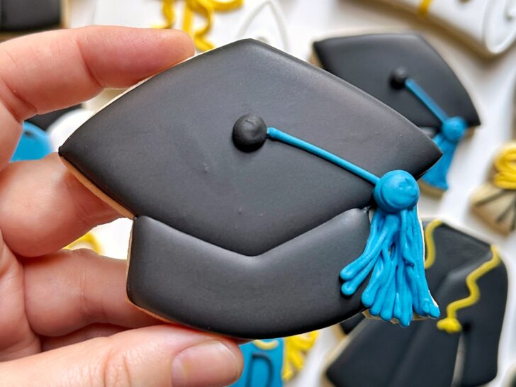 graduation cap cookie decorated with black royal icing