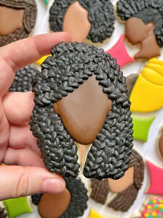 black woman with braids cookie decorated with black royal icing
