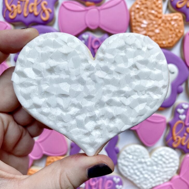 curvy heart cookie decorated with white royal icing