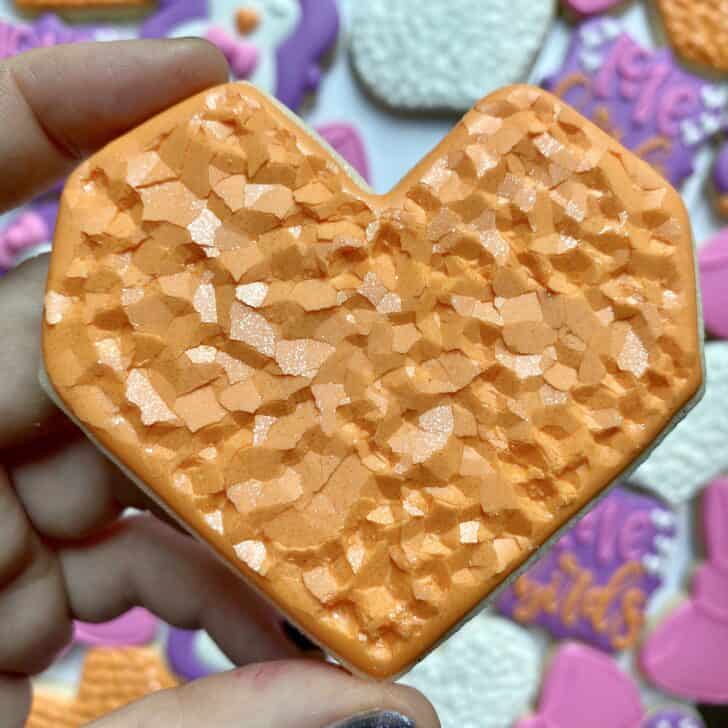 geometric heart cookie decorated with orange royal icing