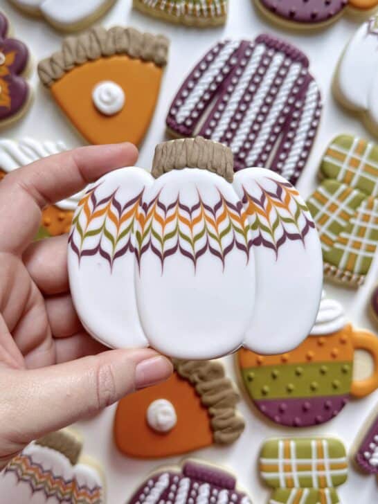 pumkpin cookie decorated with royal icing to demonstrate how much icing is needed for details