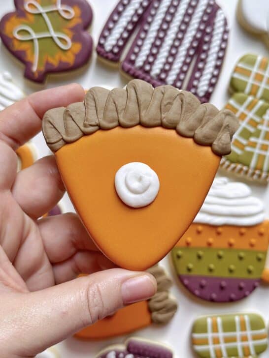 pumkpin pie cookie decorated with royal icing to demonstrate how much icing is needed for details