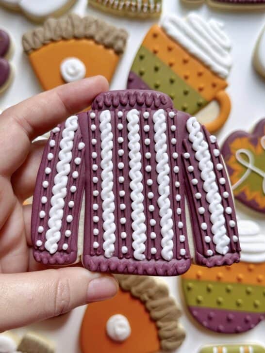 sweater cookie decorated with royal icing to demonstrate how much icing is needed for details