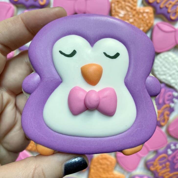 penguin cookies decorated with a bow tie and royal icing
