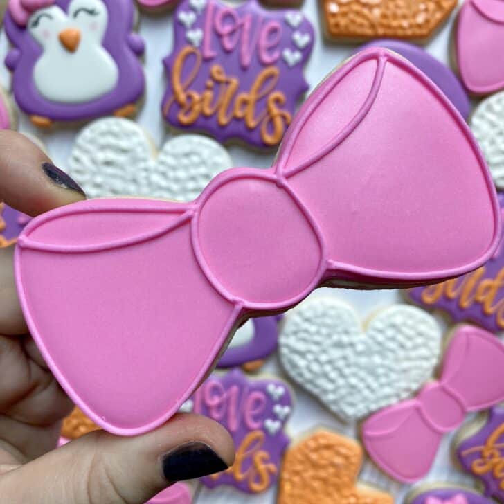 bow tie cookies decorated with pink royal icing