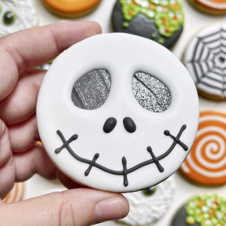 photo of circle skeleton halloween cookie decorated with royal icing
