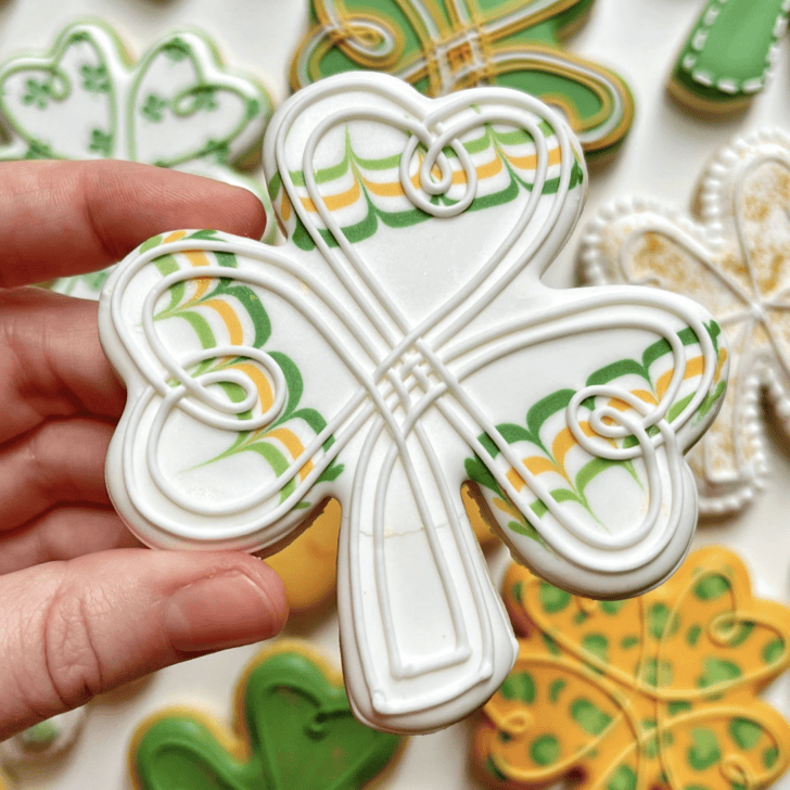 st patrick's day clover cookie decorated with royal icing and has a crack on the icing