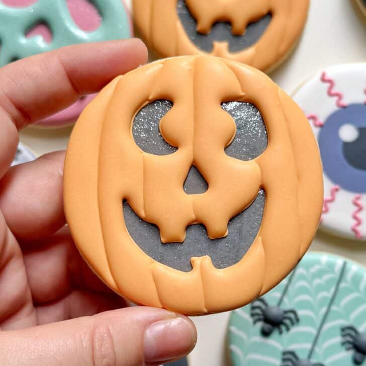 jack o lantern cookie decorated with royal icing