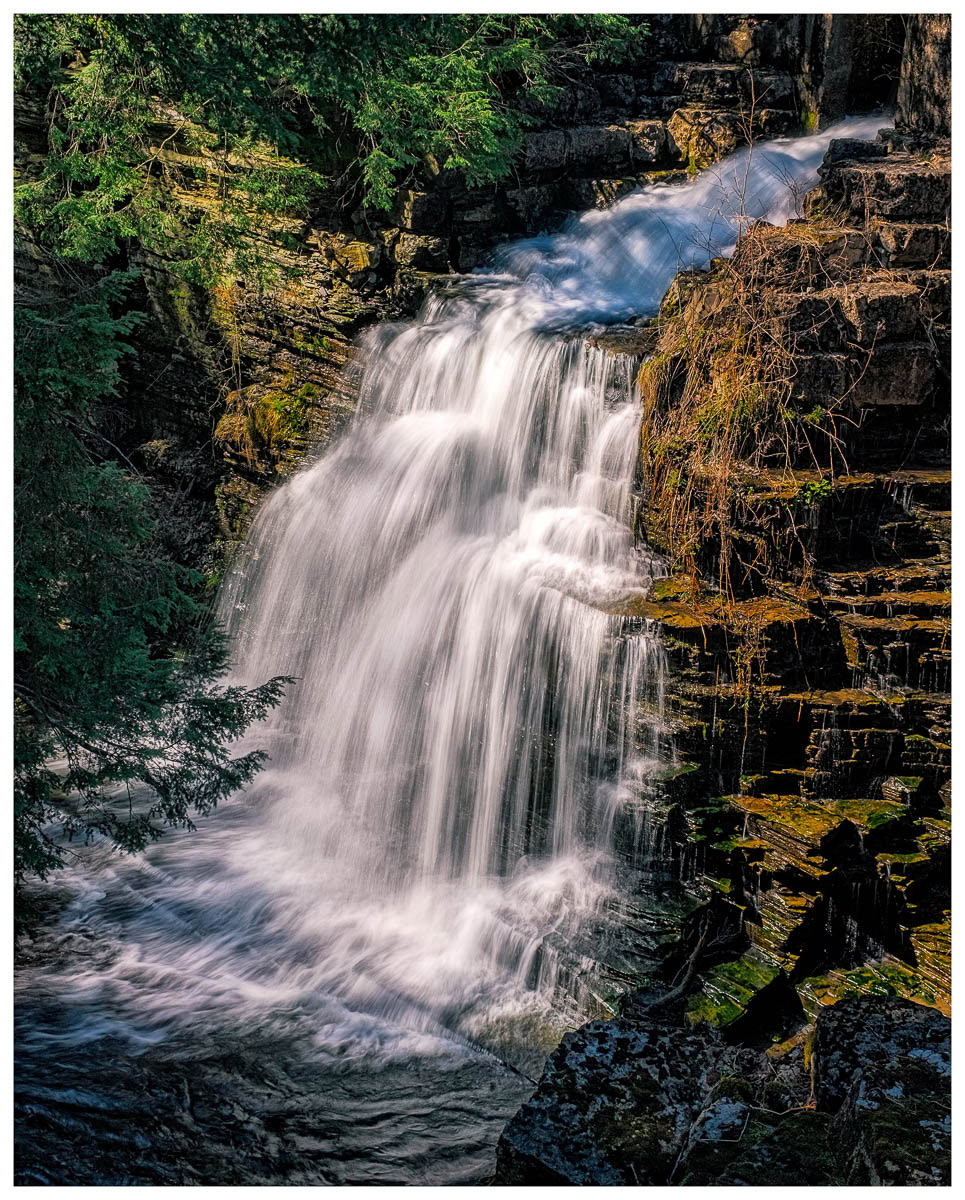 Sunlight falling on a waterfalls at Fillmore Glen State Park in Moravia, New York.