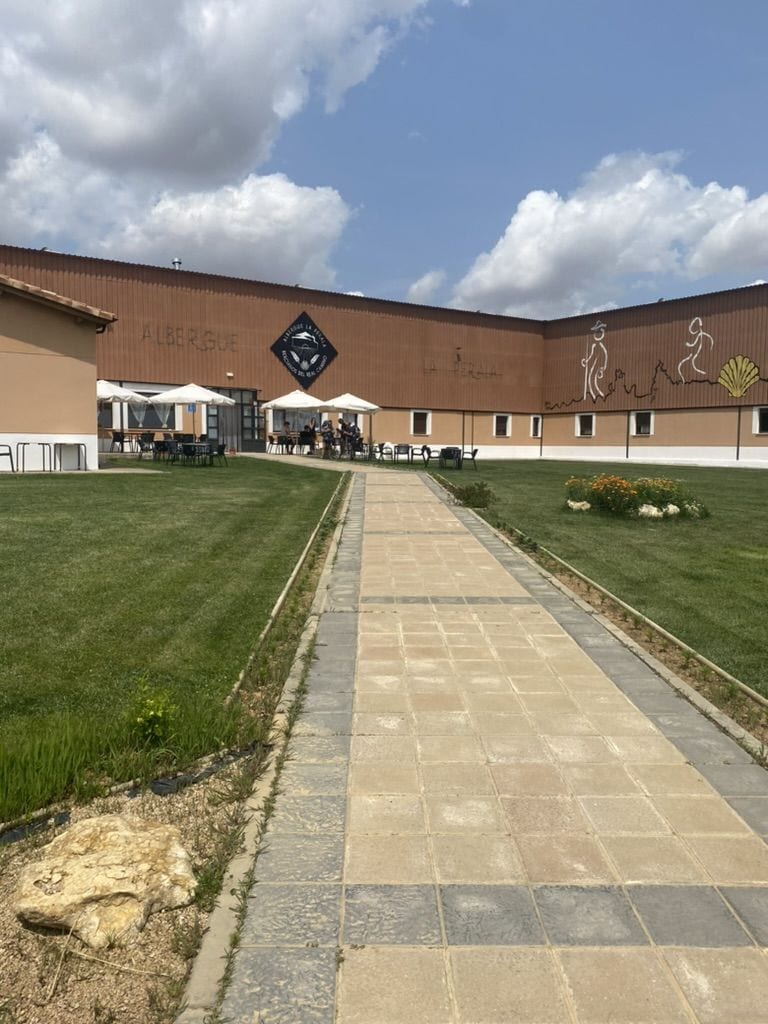 Outside of an albergue with a patio on a sunny day in Bercianos del Camino